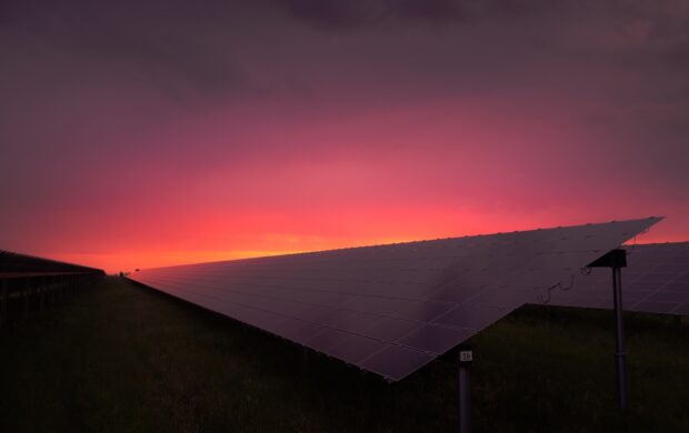black solar panel under red and gray clouds