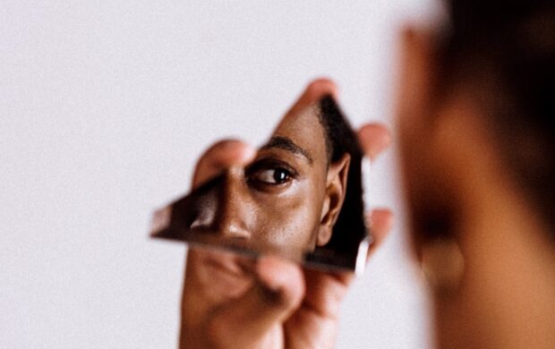 man holding broken mirror