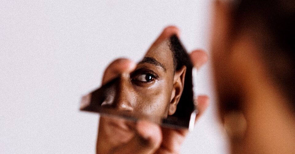 man holding broken mirror