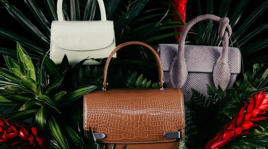 brown leather handbag on green pine tree