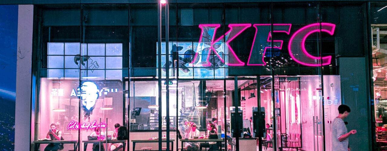 two person walking near KFC building during night time