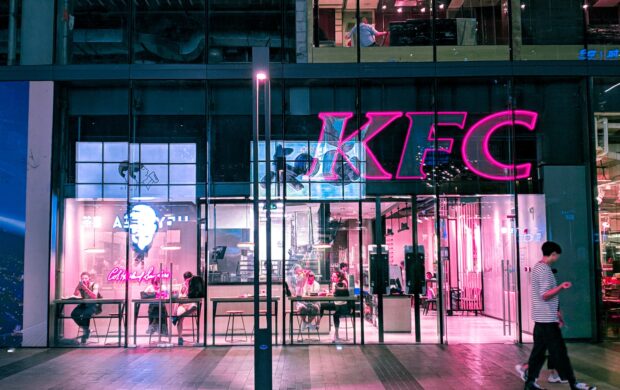 two person walking near KFC building during night time