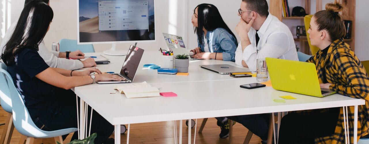 five person by table watching turned on white iMac