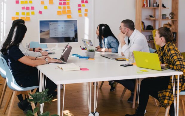 five person by table watching turned on white iMac