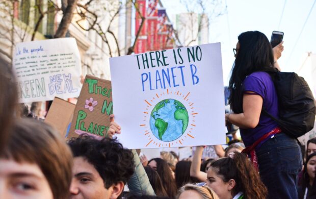 person holding there is no planet b poster