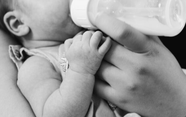 grayscale photo of baby feeding