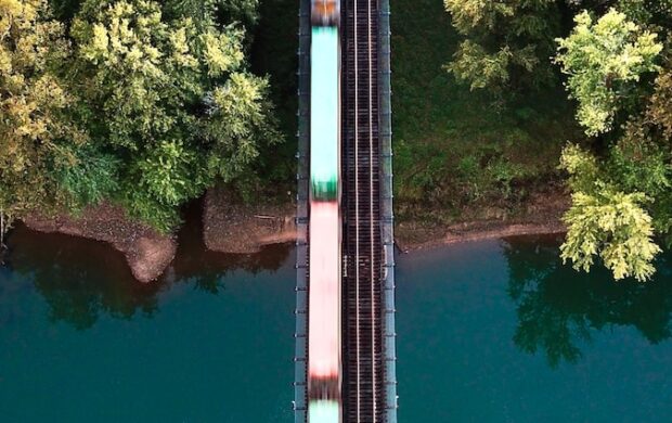 a train traveling over a bridge next to a forest