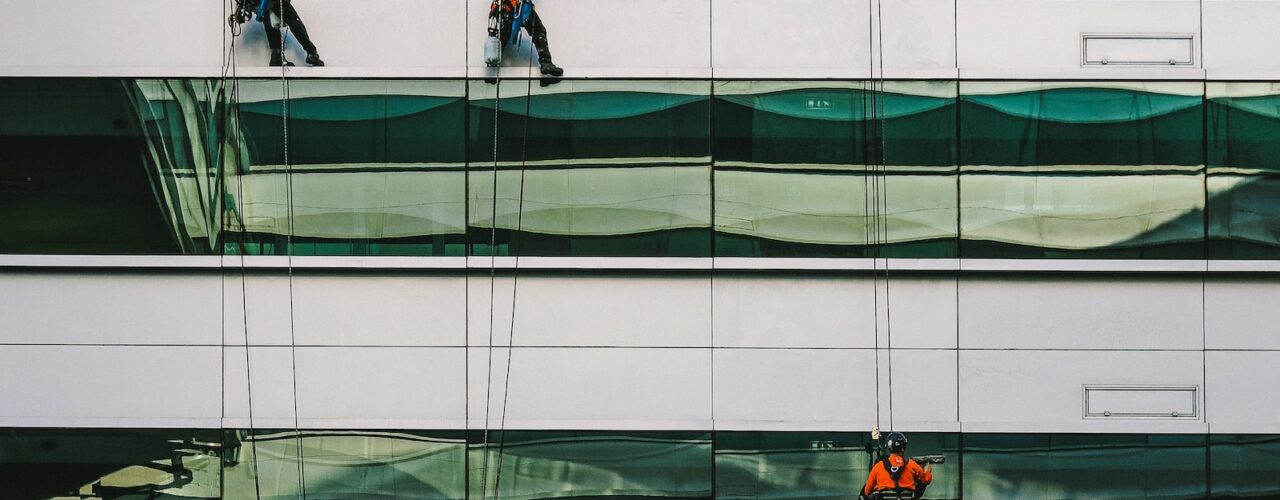 man cleaning white building