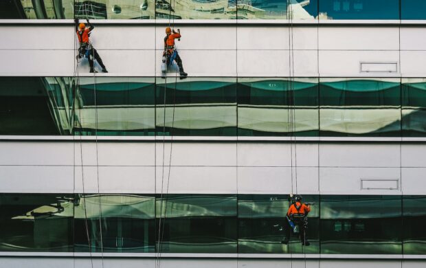 man cleaning white building