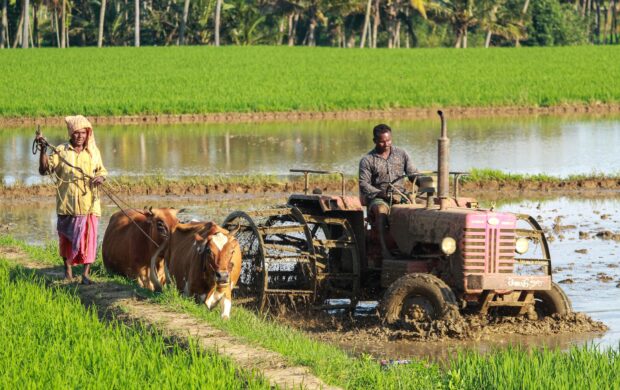 man riding farm equipment during daytime