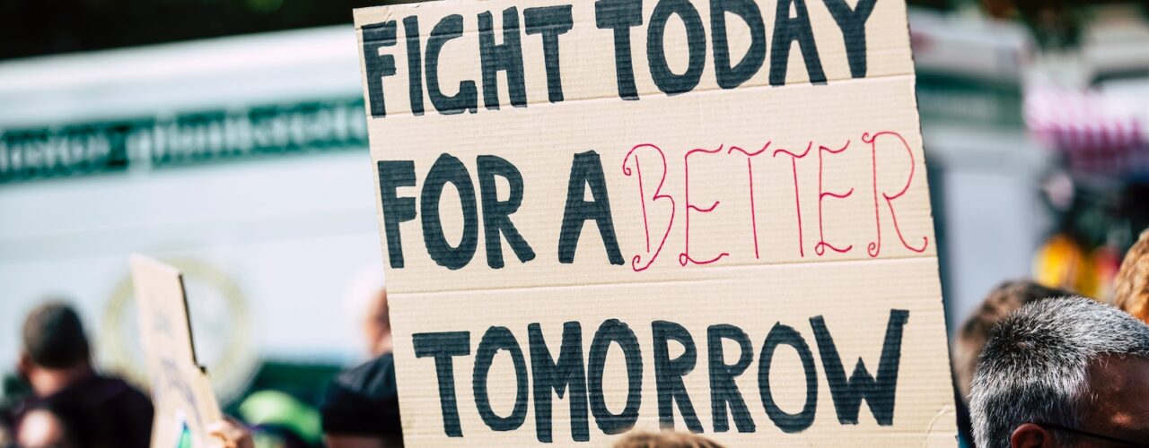 person holding fight today for a better tomorrow sign